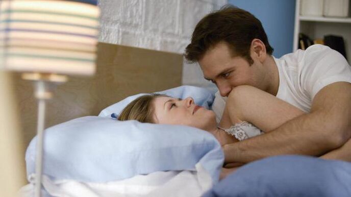 a woman in bed with a man with an enlarged penis